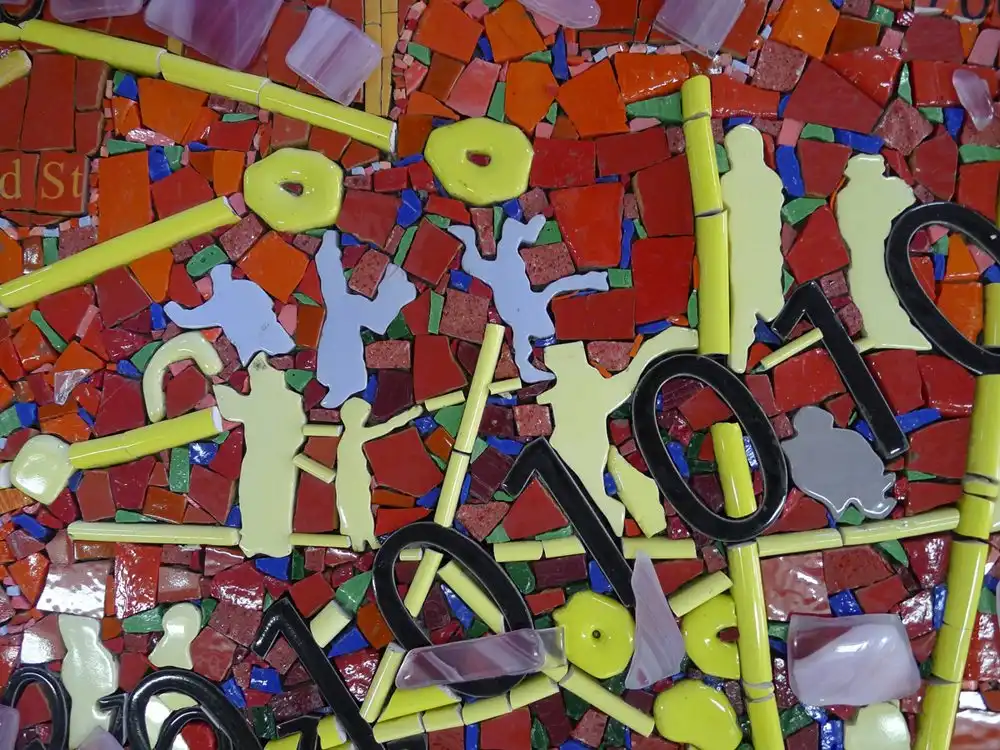 Colorful mosaic with abstract shapes, numbers, and figures. Bright reds, yellows, and purples create a lively, textured pattern.