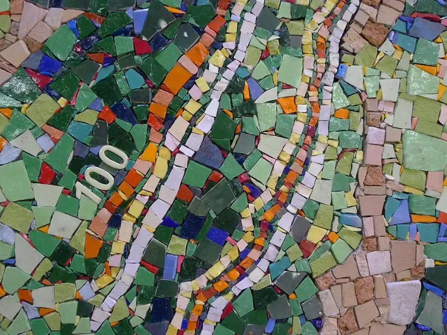 Colorful mosaic with various sized tiles in green, blue, orange, and beige, featuring the number "100" in white.